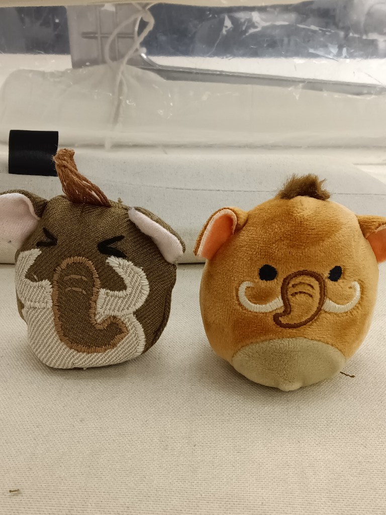 Two small mammoth toys.  One is an official squish mallow and the other is an imitation of it made from upcycled fabric 