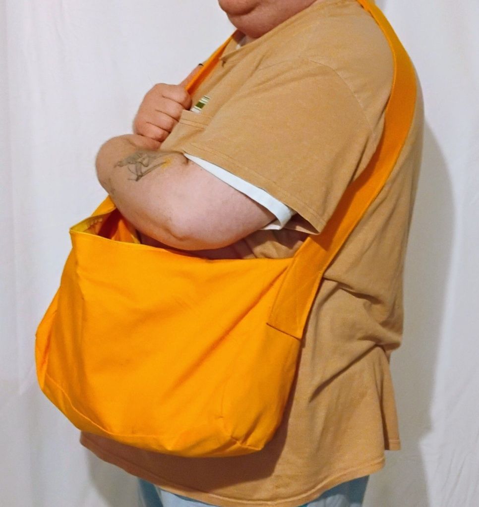 A person wearing a bright orange-yellow messenger bag