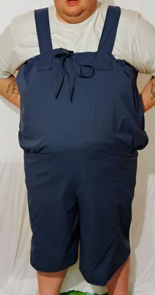 A person wearing a blue blousy wetsuit that looks like overalls